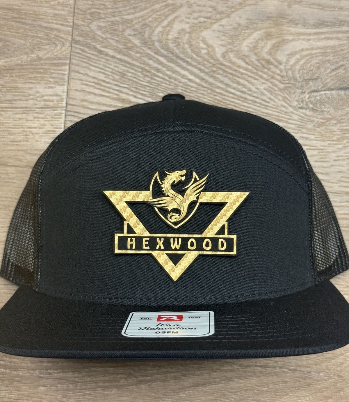 Hexwood Creations gold crest design on a black hat